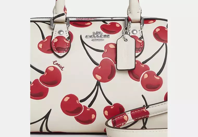 Coach Mini Rowan Crossbody 20 cm white with a cherry print.