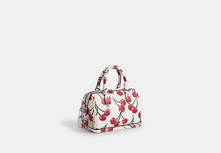 Coach Mini Rowan Crossbody 20 cm white with a cherry print.